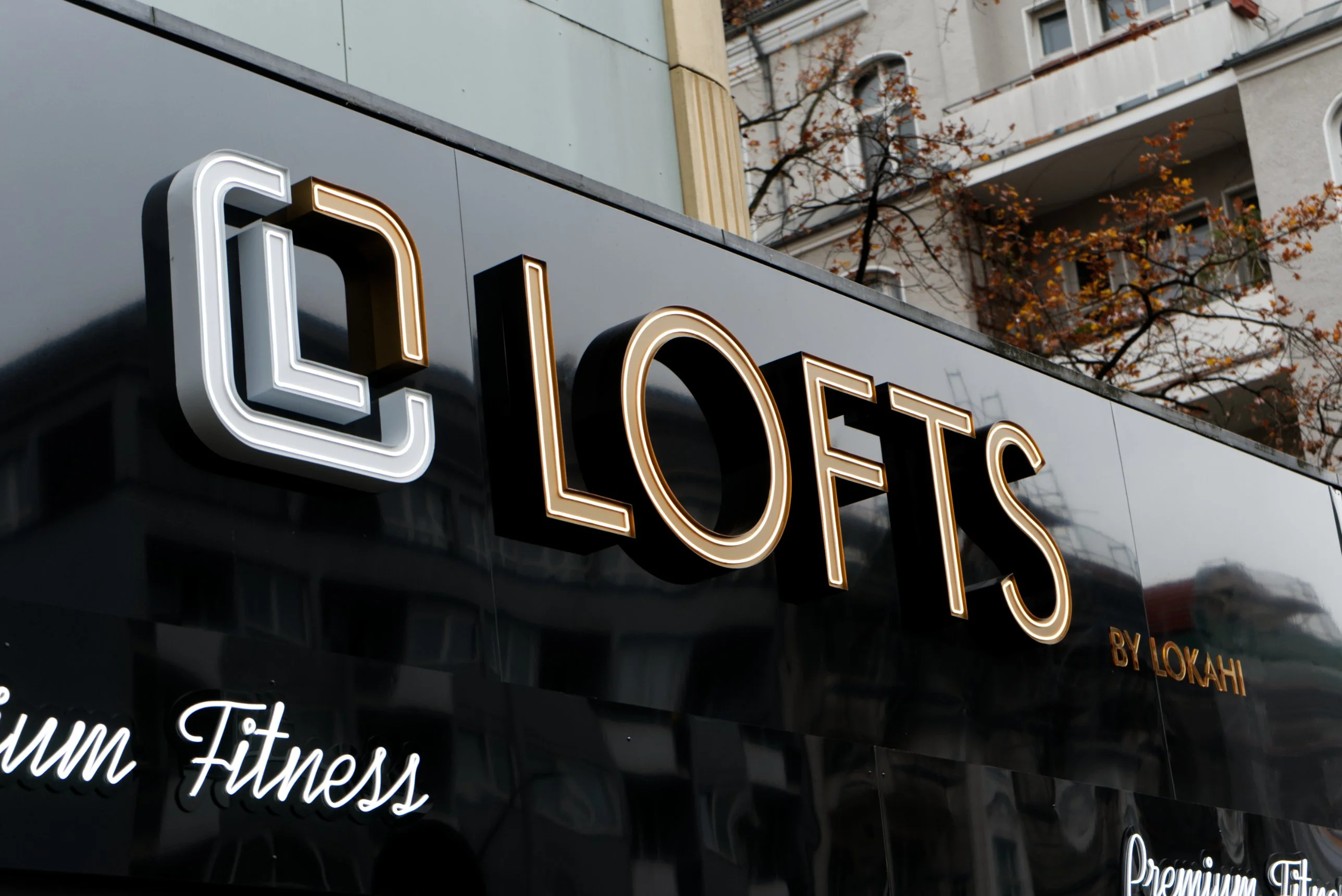 Beleuchtetes LOFTS by Lokahi Schild mit „Premium Fitness“-Schriftzug an der Fassade in Charlottenburg